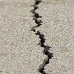 A cracked concrete road symbolizing the Venezuela earthquake and the fragile memory of disasters