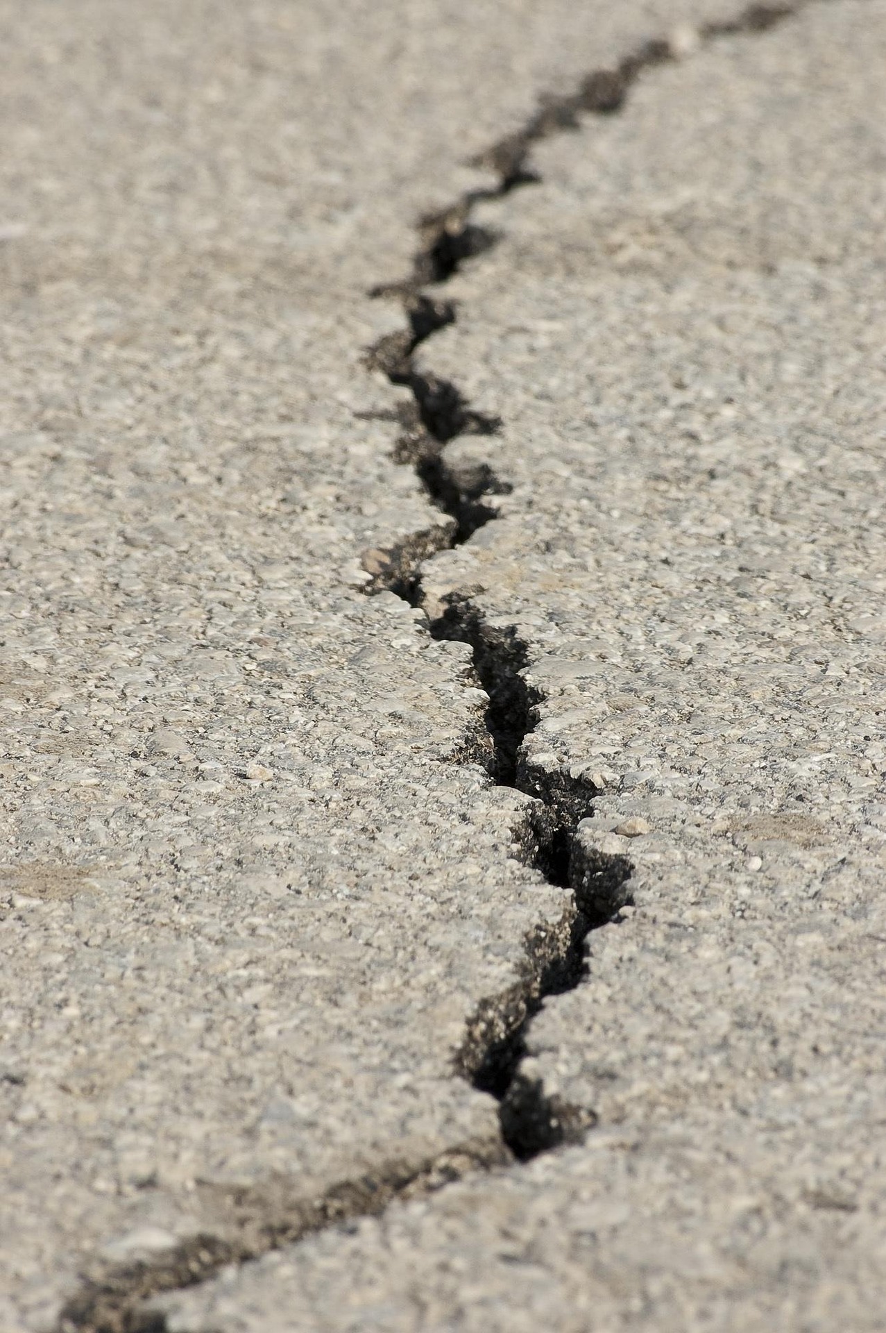 A cracked concrete road symbolizing the Venezuela earthquake and the fragile memory of disasters