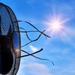 Europe heatwave shown through a broken fan under intense sunlight